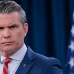 Close-up of Secretary of War Pete Hegseth as he speaks to reporters.
