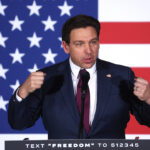 Ron DeSantis speaks in front of an American flag