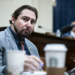 Rep. Eli Crane in a suit sitting at the dais in a congressional hearing room