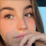 Agam Berger places her hand on her chin and looks at the camera.
