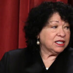Supreme Court Justice Sonia Sotomayor prepares to pose for a photo in her black robe