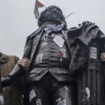 pro-Hamas protesters wrap Palestinian flag and Keffiye around the statue