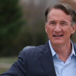 Virginia Gov. Glenn Youngkin waving his hand.