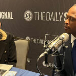A woman interviews a man on a podcast
