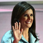 Nikki Haley waves with a grin on her face