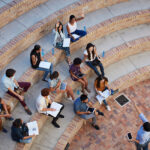 Students sit in class outside.
