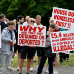 Protesters hold up signs against illegal immigration in Britain.
