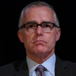 Andrew McCabe in a suit stares ahead