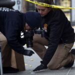 Two police officers work at a crime scene.