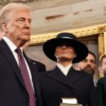 Donald Trump stands next to his wife as he raises his right hand during his swearing in ceremony.