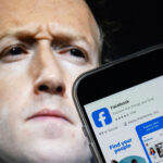 A photo illustration shows Mark Zuckerberg, CEO of Meta, with a phone displaying the Facebook app.