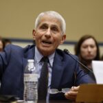 Anthony Fauci sits and raises his right hand while testifying.