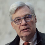 Sheldon Whitehouse in a suit and glasses