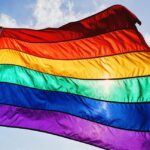 A gay pride flag flies in the wind.