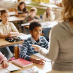 Kids in a classroom paying close attention to the teacher
