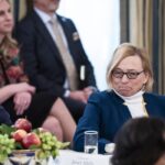 Maine Gov. Janet Mills sits at a table with an uncomfortable look on her face as President Donald Trump criticizes her policies.