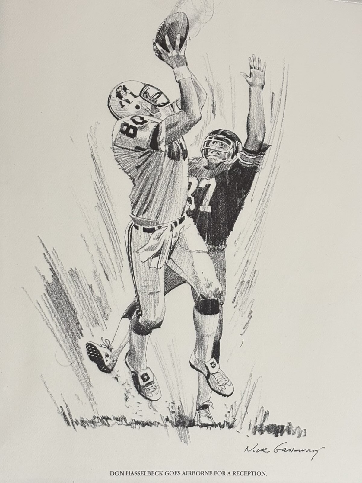 A print of a black and white drawing of Don Hasselbeck going up for a pass with a defender draped all over him.)