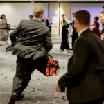 A security official runs with a bag as a shooter opens fire during the annual White House Correspondents' Association dinner in Washington, D.C., U.S., April 25, 2026. REUTERS/Jonathan Ernst