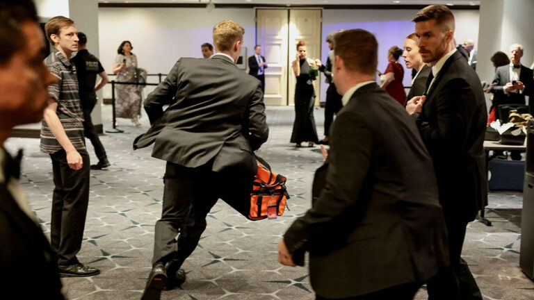 A security official runs with a bag as a shooter opens fire during the annual White House Correspondents' Association dinner in Washington, D.C., U.S., April 25, 2026. REUTERS/Jonathan Ernst