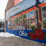 A vibrant mural on a brick wall reads “Greetings from Springfield, Ohio."