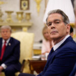 Donald Trump, Scott Bessent, and Pete Hegseth sit in the Oval Office with gold decor, two facing forward and one in the background. The atmosphere appears serious and focused, creating a sense of tension.