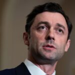 Senator Jon Ossoff is pictured in a suit and speaks, looking slightly to the side, with a neutral background and soft lighting focused on his face.