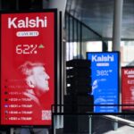 A digital sign displays betting odds with a silhouette of Donald Trump and Kalshi branding next to a modern building. Smaller screens with similar content are seen in the background.