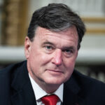 Indiana Attorney General Todd Rokita is demanding documents from the Council on American-Islamic Relations (CAIR) and Students for Justice in Palestine. Pictured: headshot of a middle-aged man with dark hair, wearing a suit and red tie.