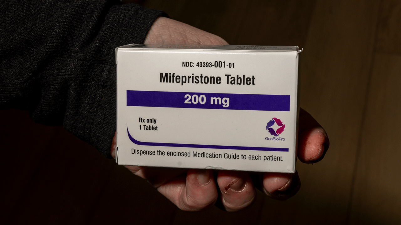 Home 1 A person holding a box of Mifepristone 200 mg tablets.
