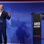 Steve Hilton and Xavier Becerra stand at individual podiums labeled Voters Decide during a televised debate on affordability.