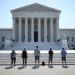 Seven people stand facing the U.S. Supreme Court building.