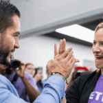 A man and a woman high-five each other while smiling.