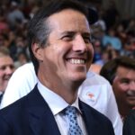 Bill Hagerty smiling in a suit and tie, surrounded by a crowd.