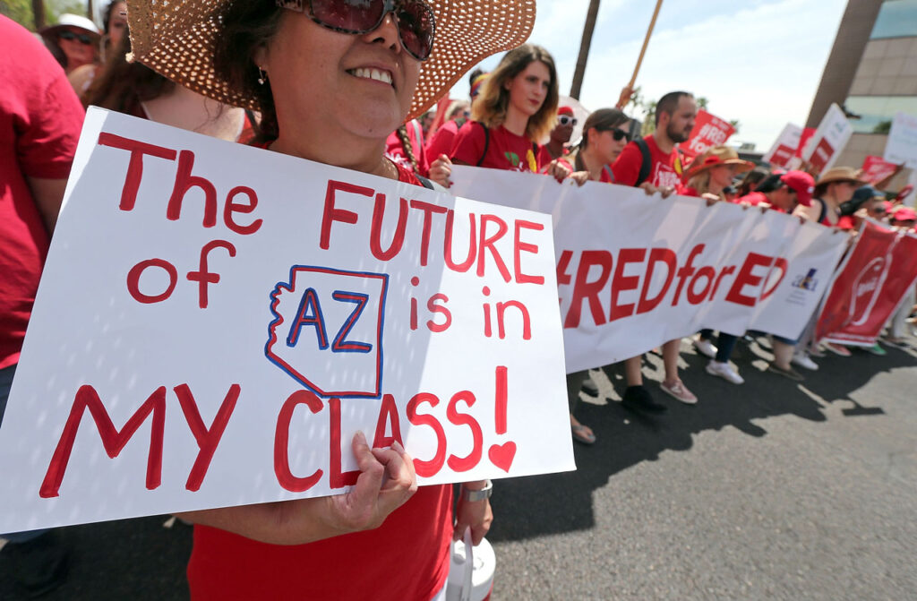A person holds a sign that says The FUTURE of AZ is in MY CLASS! during a Red for Ed protest.