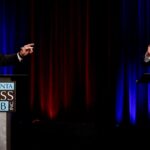 Rep. Mike Collins and Sen. Jon Ossoff are pictured in suits and stand at Atlanta Press Club podiums during a debate.