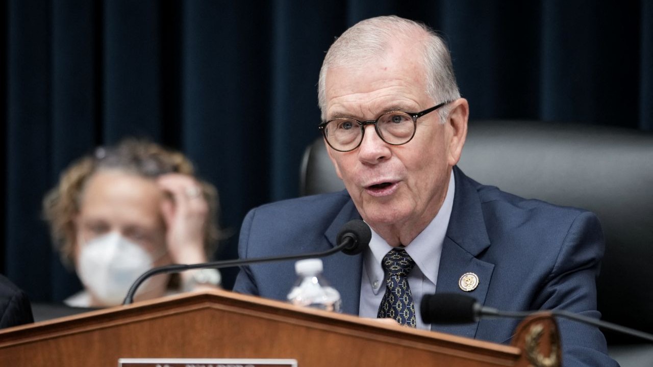 Rep. Tim Walberg is pictured in a suit and glasses and speaks into a microphone at a hearing.