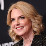 GLAAD President Sarah Kate Ellis says she supports parental choice in TV, but opposes labels that would let parents know if TV shows include LGBTQ content. Pictured: a woman with shoulder-length blonde hair and a black polka-dot top smiles at an event with a dark background featuring white text.