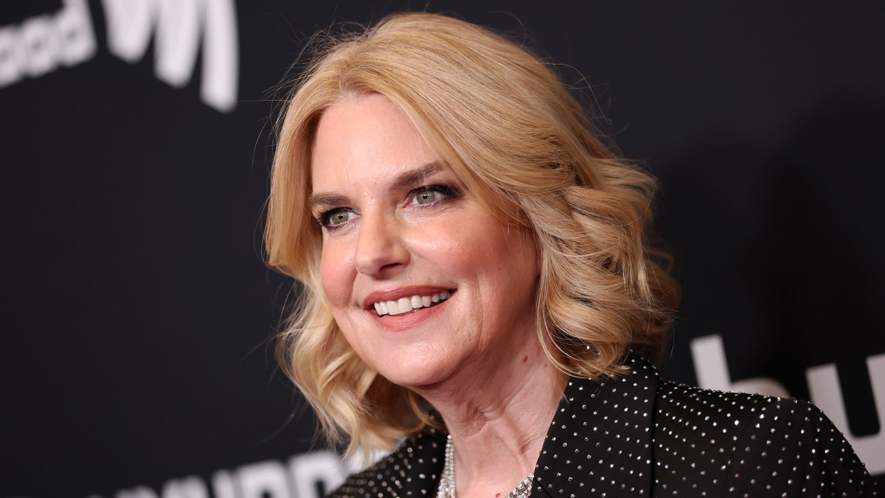 GLAAD President Sarah Kate Ellis says she supports parental choice in TV, but opposes labels that would let parents know if TV shows include LGBTQ content. Pictured: a woman with shoulder-length blonde hair and a black polka-dot top smiles at an event with a dark background featuring white text.