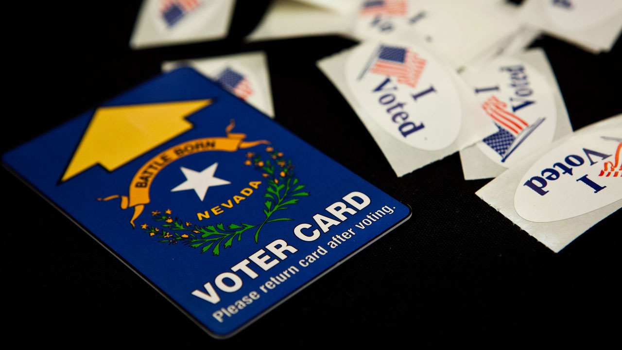 A Nevada voting card surrounded by "I Voted" stickers on a black background.