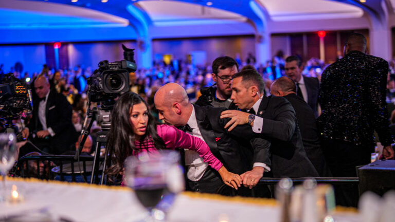 White House Deputy Chief of Staff Steven Miller protects his wife as agents try to usher him out of White House Correspondents' Dinner.