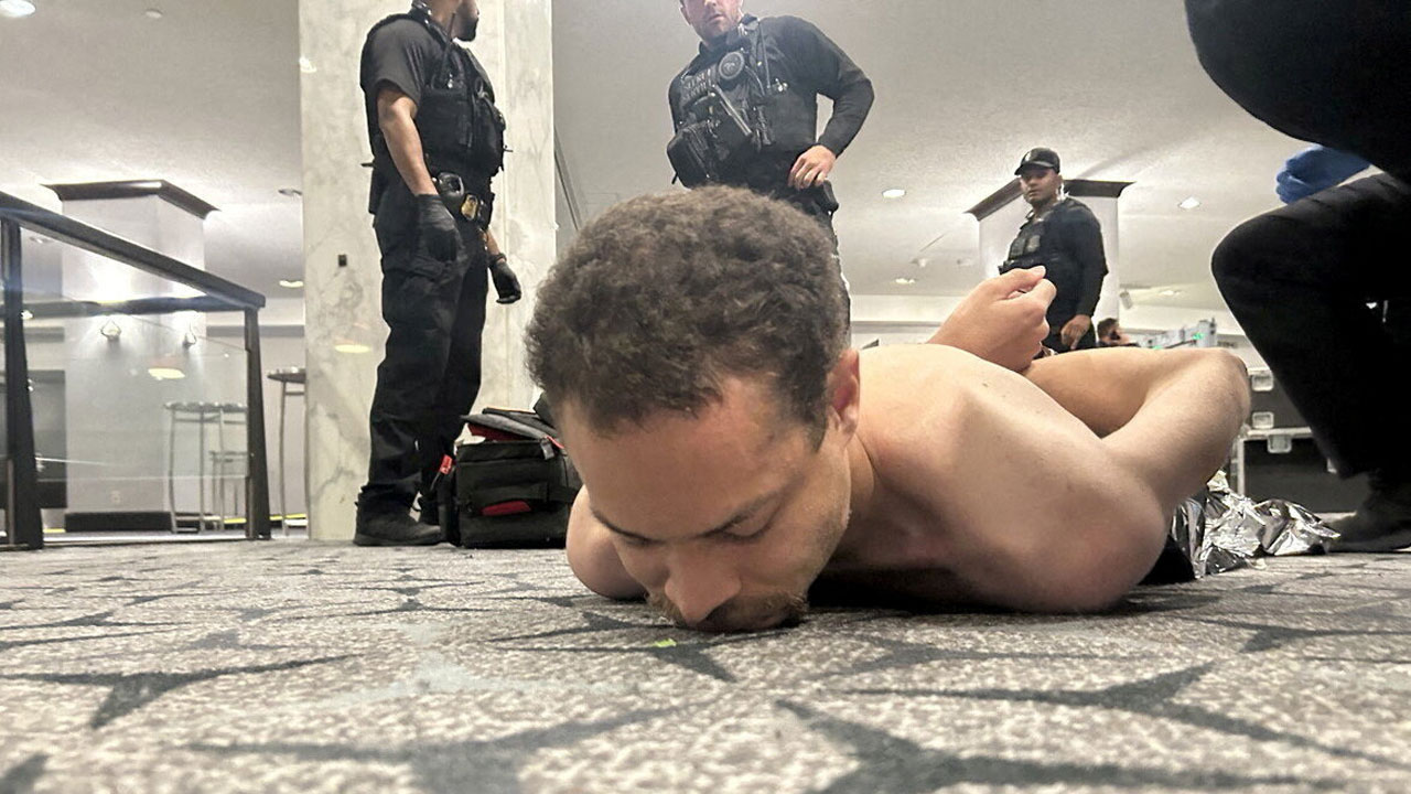 Law enforcement personnel detain Cole Tomas Allen, a suspect in the shooting incident at the White House Correspondents' Association dinner, in Washington