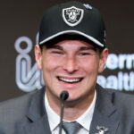 A close-up of a beaming Fernando Mendoza in a Las Vegas Raiders cap.