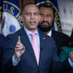 Hakeem Jeffries points upward during press conference with fellow Democrats.