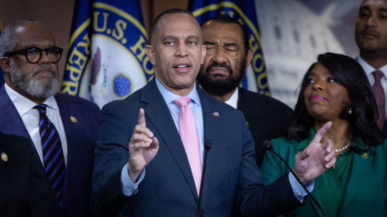 Hakeem Jeffries points upward during press conference with fellow Democrats.