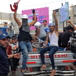 A group of Palestinians on the back of a pickup truck celebrate after returning from Oct. 7 massacre.