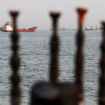 Tankers on the Strait of Hormuz as seen through posts on an Iranian beach.