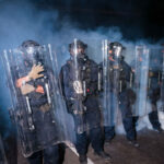 New Jersey Democrats Stoke Anti‑ICE Chaos, Then Claim Credit for Restoring Order 3 New Jersey State Police stand guard in front of protesters outside Delaney Hall which is being used as an ICE detention center. (Photo by Adam Gray/Getty Images)