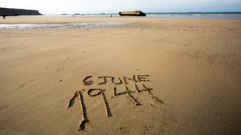 The date 6 June 1944 written in the sand of the beaches of Normandy, France.