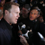 Profile of Spencer Pratt in black as he talks to reporters.
