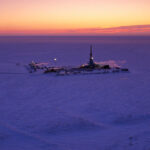 An oil well at Alaska's Prudhoe Bay as the sun sets.